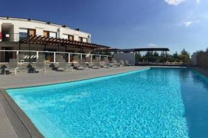 une grande piscine bleue à côté d'un bâtiment dans l'établissement Douce Provence au calme face à la piscine 104, à Éguilles