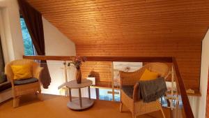 uma sala de estar com duas cadeiras e uma mesa em Haus Lucia em Schönwald