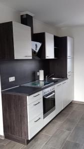 a kitchen with white cabinets and a stove top oven at Ferienwohnung Völkner in Hamdorf