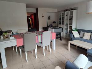 sala de estar con mesa, sillas y piano en A Bordeaux, Climatisée avec billard, en Le Bouscat