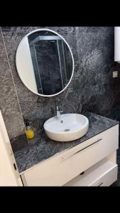 uma casa de banho com um lavatório e um espelho num balcão em Damast Lux apartments 20 em Ohrid