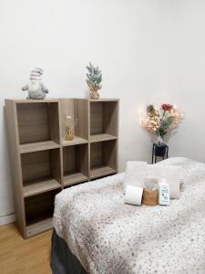 1 dormitorio con 1 cama con toallas y estanterías en Casa de Ciss, en Madrid