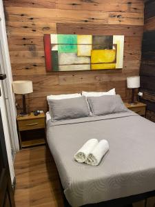 a bedroom with a bed with two towels on it at Tremo Parque Bustamante in Santiago