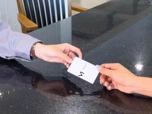 two hands holding a piece of paper on a table at V1 boutique hotel in Kanchanaburi City +109 photos