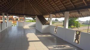 a building with a roof and a tiled walkway at 2 chambres salon Baguida in Lomé