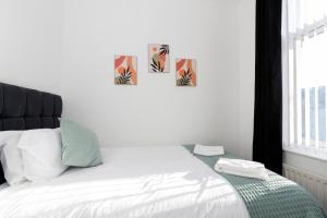 a bedroom with a bed with three pictures on the wall at Bright House in Hartlepool