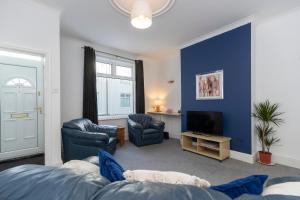 a living room with blue walls and a tv at Bright House in Hartlepool
