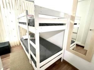 a white bunk bed in a room with a mirror at SeaHomes Vacations - CORAL SUN in Fenals Beach in Lloret de Mar +22 photos
