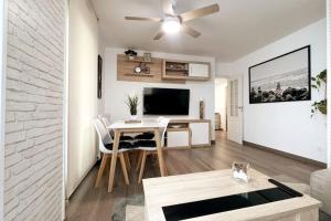 sala de estar con mesa y sala de estar con ventilador de techo. en SeaHomes Vacations - CORAL SUN in Fenals Beach en Lloret de Mar