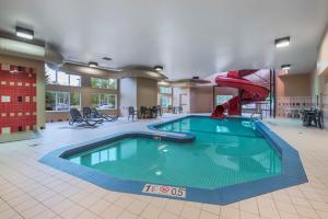 a swimming pool with a slide in a building at Quality Inn Airport in Moncton