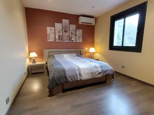 ein Schlafzimmer mit einem Bett, zwei Lampen und einem Fenster in der Unterkunft Villa Greg in Saint-Marcel-lès-Valence