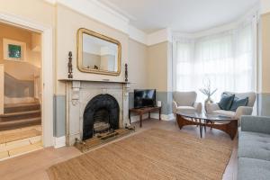 a living room with a fireplace and a mirror at Oakwood House in Dublin