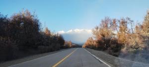 an empty road with a mountain in the distance at Mana in San Martín de los Andes