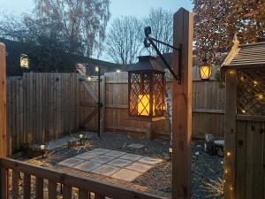 a lantern hanging on a fence with candles at Eden Stays in Stivichall