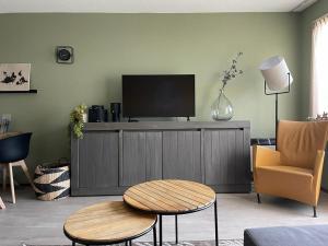 een woonkamer met een flatscreen-tv op een kast bij Appartement Senang, Resort Amelander Kaap in Hollum