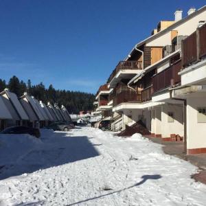 a snow covered street in front of a building at BJELAŠNICA BEX APARTMANI in Bjelašnica