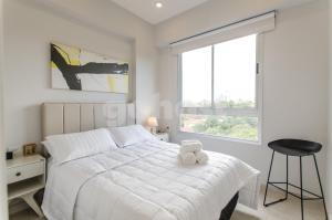 Un dormitorio con una cama blanca con un osito de peluche. en Exquisite And Comfortable Villa Morra Apartment, en Asunción