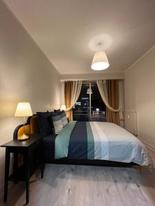 um quarto com uma cama e uma mesa com um candeeiro em AVENUE DE CHAMPAGNE em Épernay