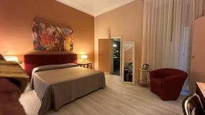 a hotel room with a bed and a chair at Hotel Roma in Bologna