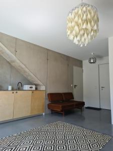 een woonkamer met een bank en een kroonluchter bij Vintage studio am Chiemsee in Übersee