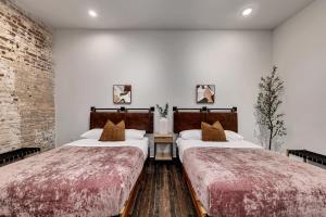 two beds in a room with white walls at Loft Style Spacious Lux Apt 102, Sleeps 6 in Atlanta