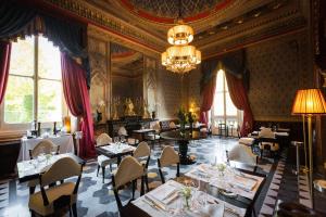 een eetkamer met tafels en stoelen en een kroonluchter bij Villa Cora in Florence