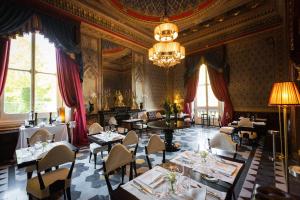 a dining room with tables and chairs and a chandelier at Villa Cora in Florence