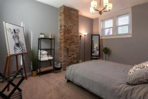 a bedroom with a bed and a brick wall at Cozy Apt in Walkable Area Downtown with Parking in Cincinnati +18 photos