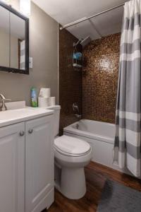 a bathroom with a toilet and a sink and a tub at Cozy Apt in Walkable Area Downtown with Parking in Cincinnati