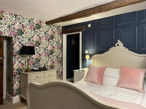 a bedroom with a white bed with pink pillows at Low Fell in Ulverston