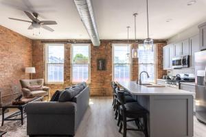 een open keuken en een woonkamer met een bakstenen muur bij Rhinegeist next door - Free streetcar - Walk OTR in Cincinnati