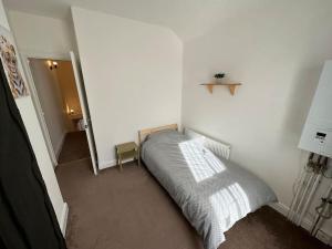 1 dormitorio con 1 cama en una pared blanca en Modern 3BD Home Doncaster South Yorkshire en Doncaster
