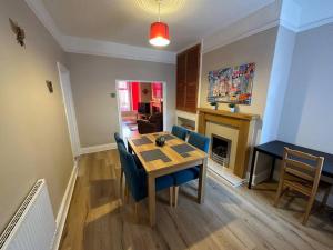 a dining room with a table and chairs and a fireplace at Modern 3BD Home Doncaster South Yorkshire in Doncaster