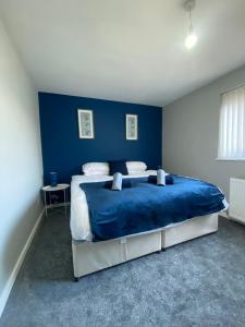 a blue bedroom with a bed with a blue wall at Modern Home with Free Parking Sleeps 6 in Leeds
