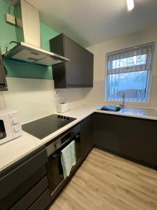 a kitchen with a sink and a stove top oven at Modern Home with Free Parking Sleeps 6 in Leeds