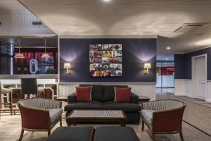 a lobby with a couch and tables and chairs at Hotel Apartamento Solverde in Espinho