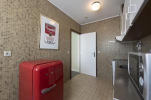 a kitchen with a red refrigerator in a room at Hotel Apartamento Solverde in Espinho