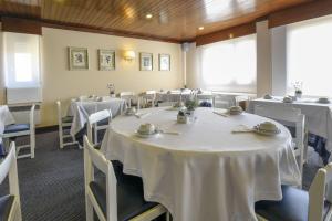 a room with tables and chairs with white table cloth at Hotel Apartamento Solverde in Espinho