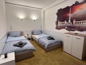 een kamer met 2 bedden en een schilderij aan de muur bij Fancy home Budapest in Boedapest