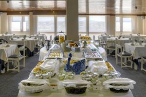 a dining room with white tables and white chairs at Hotel Apartamento Solverde in Espinho