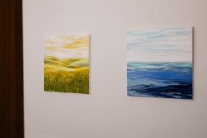 um grupo de três pinturas em uma parede branca em Art Novella Gallery em Florença