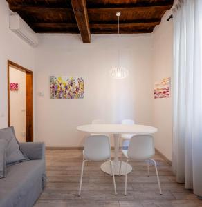 uma sala de estar com uma mesa e cadeiras brancas em Art Novella Gallery em Florença