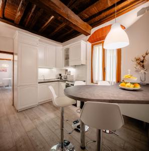 uma cozinha com armários brancos e uma mesa e cadeiras em Art Novella Gallery em Florença
