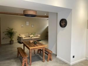 a living room with a table and a couch at Superbe appartement avec jacuzzi et jardin privé in Marlhes