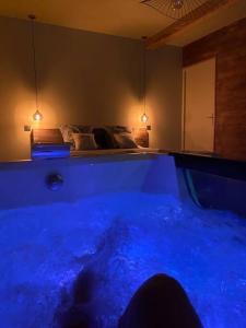 a blue tub in a room with a bed at Superbe appartement avec jacuzzi et jardin privé in Marlhes