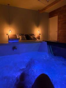 a blue tub in a room with a bed at Superbe appartement avec jacuzzi et jardin privé in Marlhes +2 photos