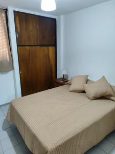 1 dormitorio con 1 cama grande y puerta de madera en Nueva Córdoba - Ambrosio Olmos 895 en Córdoba