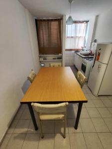 cocina con mesa de madera con sillas y nevera en Nueva Córdoba - Ambrosio Olmos 895 en Córdoba