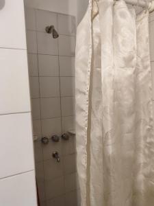 y baño con ducha con cortina blanca. en Nueva Córdoba - Ambrosio Olmos 895 en Córdoba