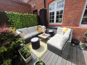 a patio with a white couch and a table at The Victorian Rooms in Surbiton